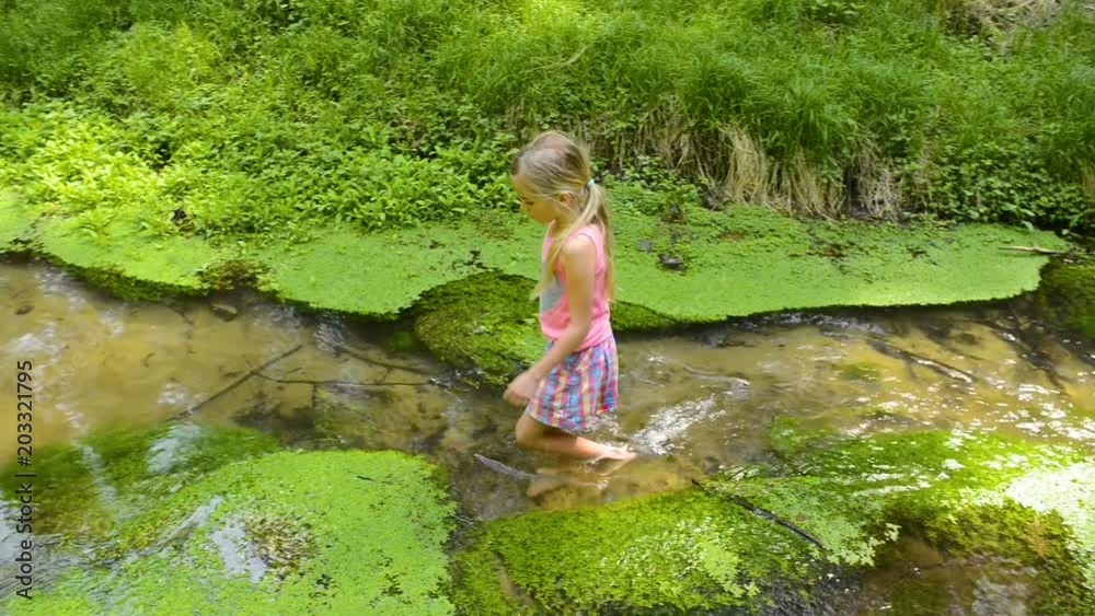 Child cute blond girl playing in the creek. Summer children fun. Child cute blond girl playing in the creek. Summer children fun.