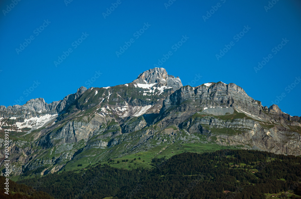 Alpine mountain landscape with forests and blue sky, near Saint-Gervais-Les-Bains. A famous ski resort located in Haute-Savoie Province, near the Mont Blanc in the French Alps.