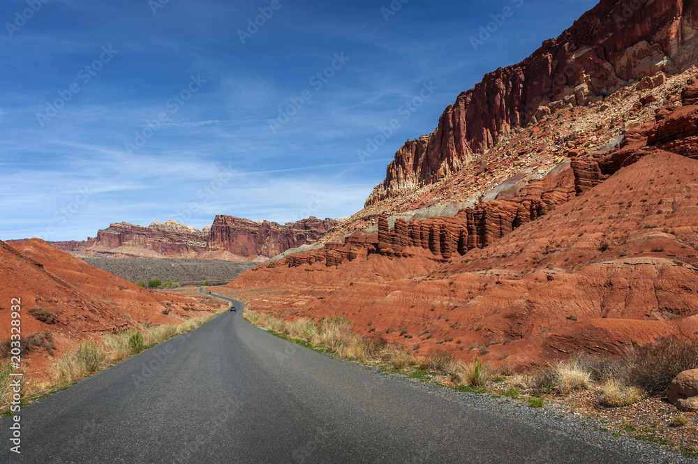 Highway to Capitol Reef National Park, Utah. This highway travels through red sandstone rock canyons and scenic desert terrain.