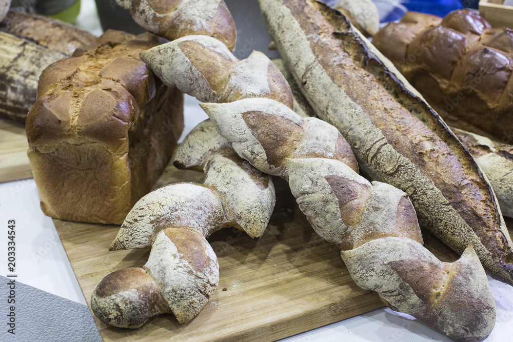 Fototapeta premium Fresh bread on table close-up. Fresh bread on the kitchen table The healthy eating and traditional bakery