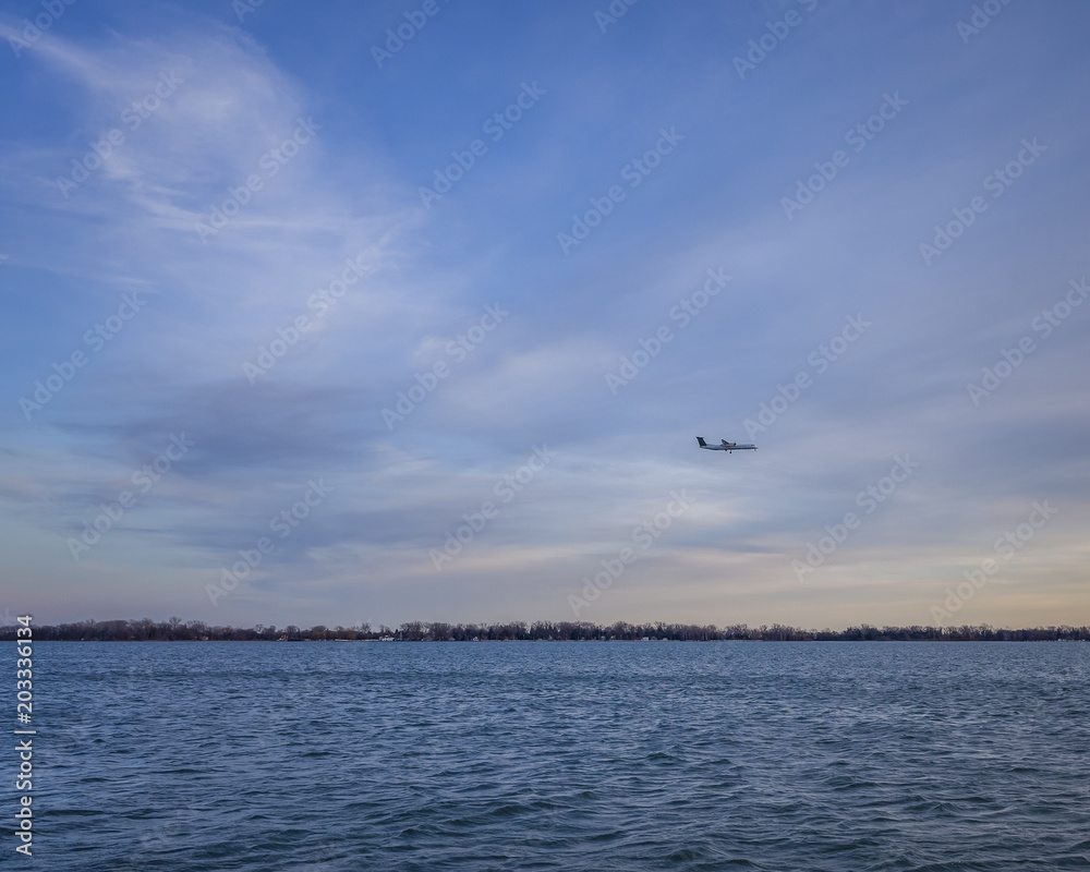 Sunset at Lake Ontario . Plane  approaching for landing near Billy Bishop Airport in Toronto