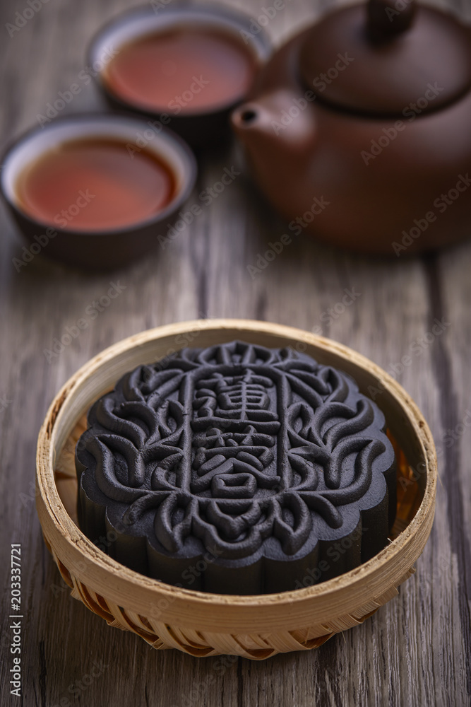 Chinese mid autumn festival foods. Snow skin mooncake on wooden table with text Black Chinese mid autumn festival foods. Snow skin mooncake on wooden table with text Black
