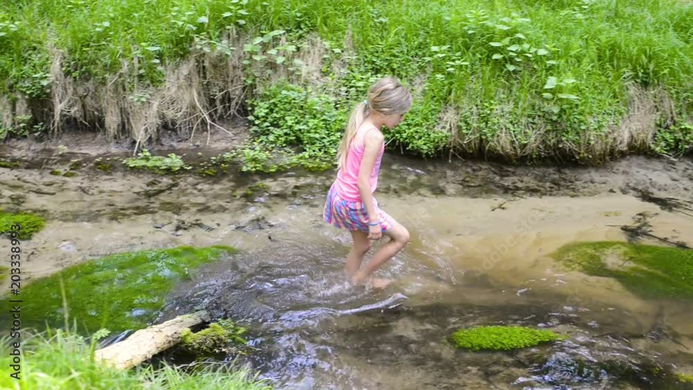 Child cute blond girl playing in the creek. Summer children fun. Child cute blond girl playing in the creek. Summer children fun.