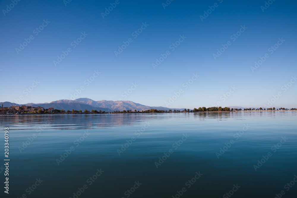 beautiful landscape with tranquil water and green vegetation on coast at sunny day, egirdir,  turkey