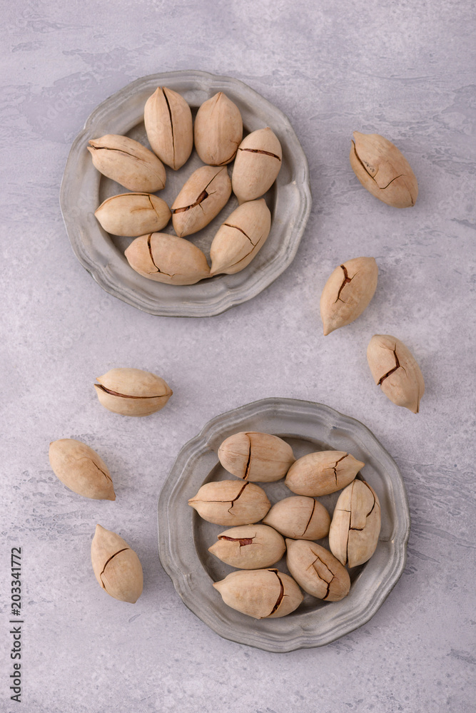 Pecan nuts in plate and scattered Pecan nuts in plate and scattered