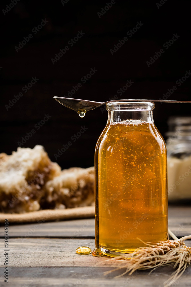 Linden honey in a transparent glass bottle Linden honey in a transparent glass bottle