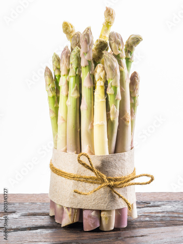 Bundle of cultivated white asparagus on wooden board. White background.