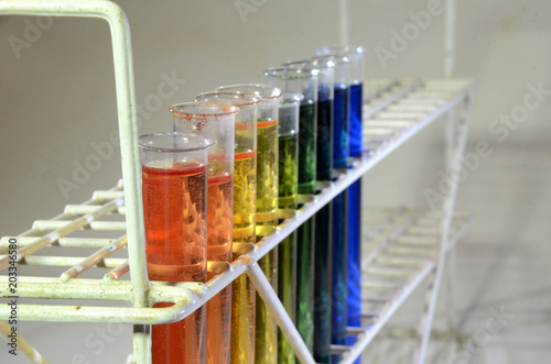 Different states of Bromothymol blue, from front red for strong acid, via weaker acids to green =neutral, then nuances of blue for different states of alkaline content. photo