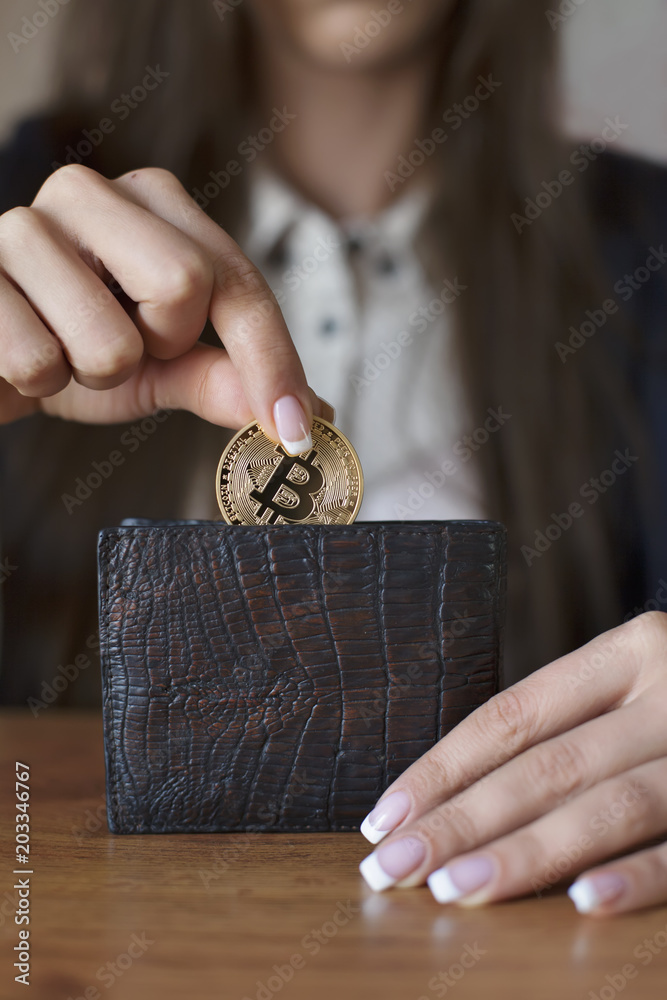 Obraz premium Successfully woman put a Bitcoin into wallet. Crypto coin saving.