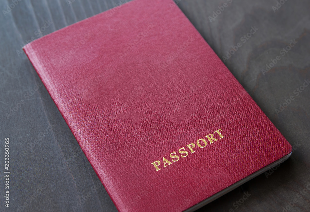 Red passport on a grey dark background