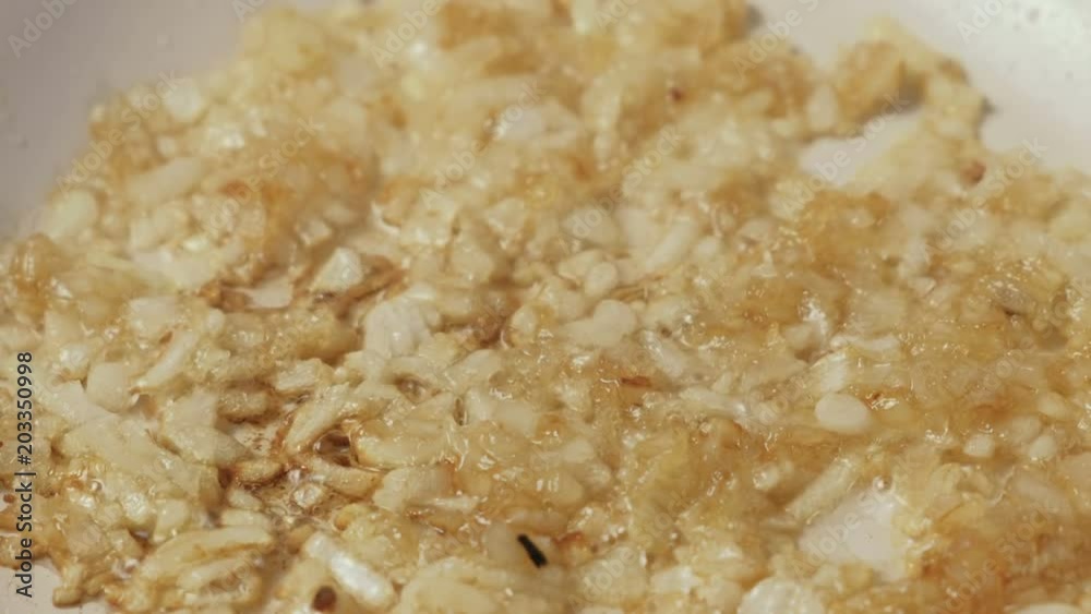 Close-up of onions fried in a pan until Golden brown.