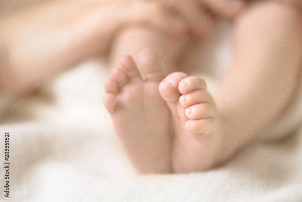 Newborn baby feet on creamy blanket. Mom and her child. Maternity, family, birth concept. Copy space for your text. Newborn baby feet on creamy blanket. Mom and her child. Maternity, family, birth concept. Copy space for your text.