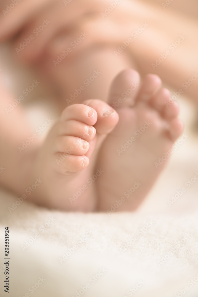 Newborn baby feet on creamy blanket. Mom and her child. Maternity, family, birth concept. Copy space for your text. Newborn baby feet on creamy blanket. Mom and her child. Maternity, family, birth concept. Copy space for your text.