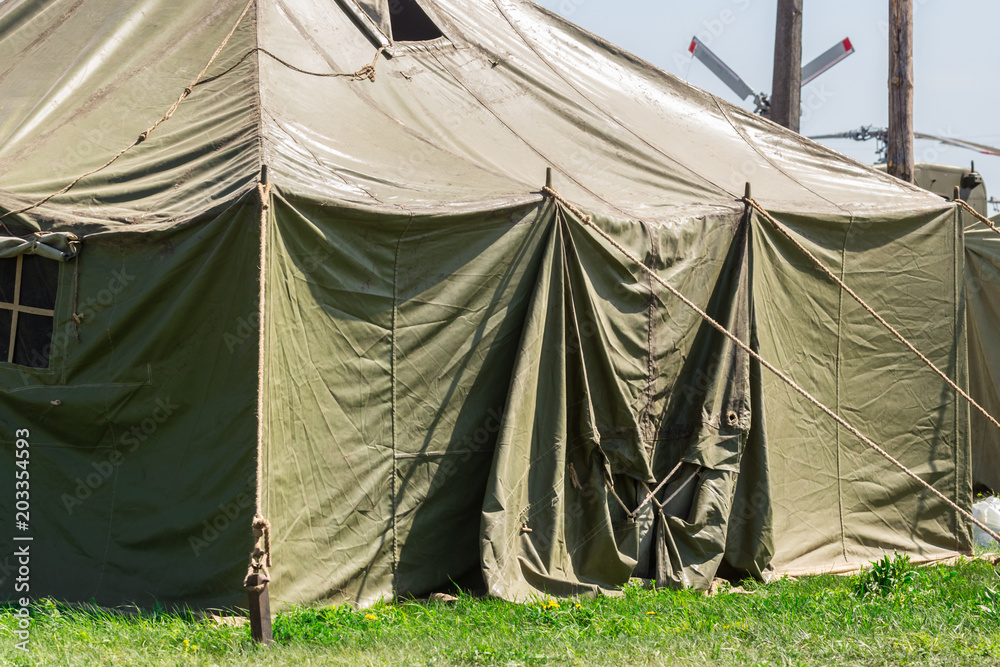 Detail with the exterior of a green military tent. summer Stock Photo