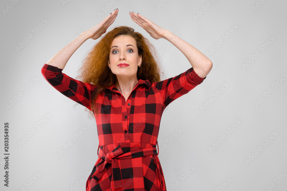 Portrait of beautiful redhead happy young woman smiling showing funny gesture on gray background Portrait of beautiful redhead happy young woman smiling showing funny gesture on gray background