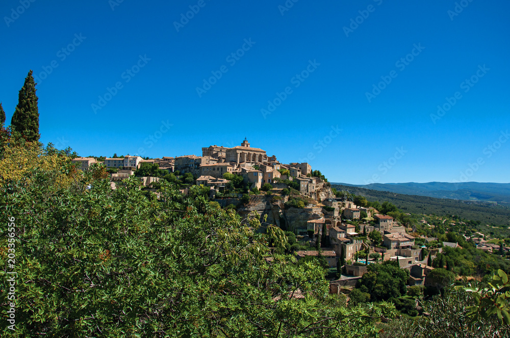 Panoramic view of the village of Gordes on top of a hill and under sunny blue sky. Located in the Vaucluse department, Provence region, in southeastern France