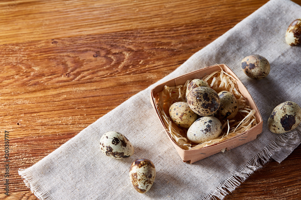 Quail eggs in the container over rustic wooden table, close-up, high angle view, selective focus. Quail eggs in the container over rustic wooden table, close-up, high angle view, selective focus.