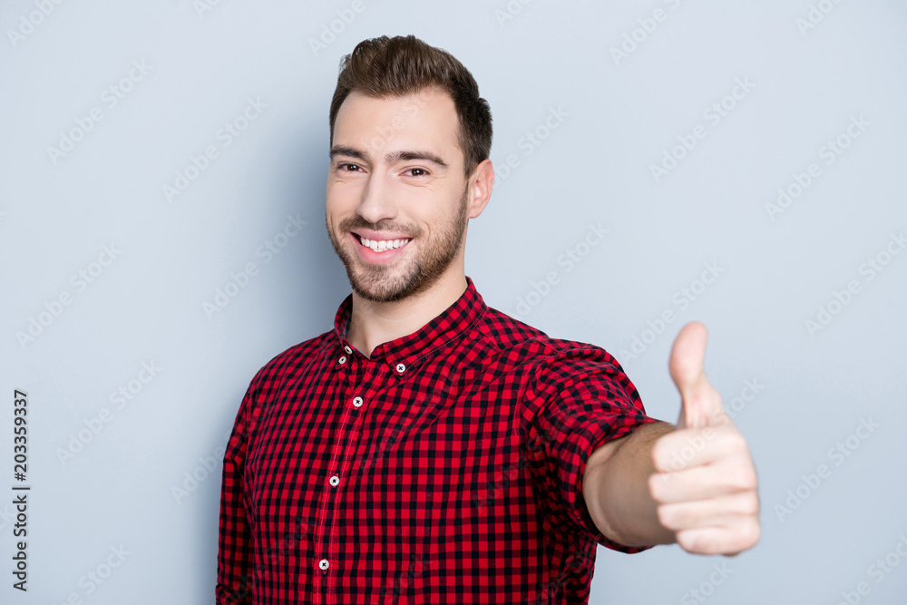 Well done! Great job! Portrait of cheerful excited with toothy beaming smile glad businessman dressed in red checkered shirt, he is presenting thumb-up to you, isolated on gray background Well done! Great job! Portrait of cheerful excited with toothy beaming smile glad businessman dressed in red checkered shirt, he is presenting thumb-up to you, isolated on gray background