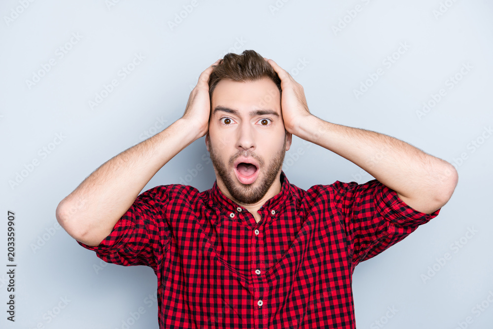 So unexpected and incredible! Embarrassed mixed-up confused unlucky person clothed in red checkered casual shirt, he is touching his head doesn't understand the situation, isolated on gray background So unexpected and incredible! Embarrassed mixed-up confused unlucky person clothed in red checkered casual shirt, he is touching his head doesn't understand the situation, isolated on gray background