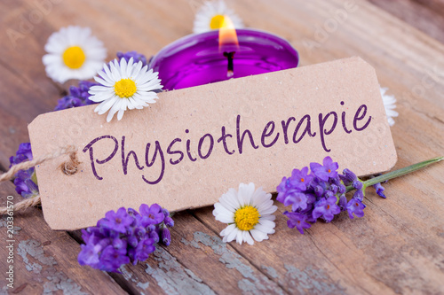 Physiotherapie  -  Schild mit Text, Lavendelblüten und Kerze auf Holz