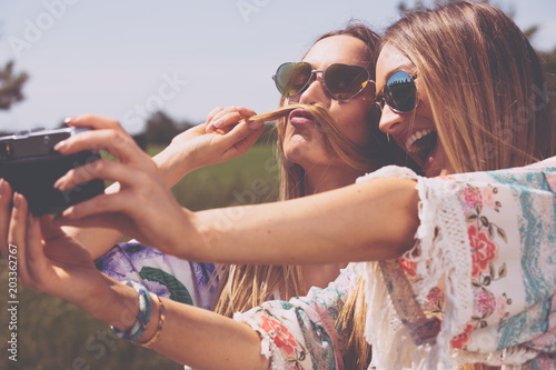 zwillings schwestern machen selfies mit einer retro kamera