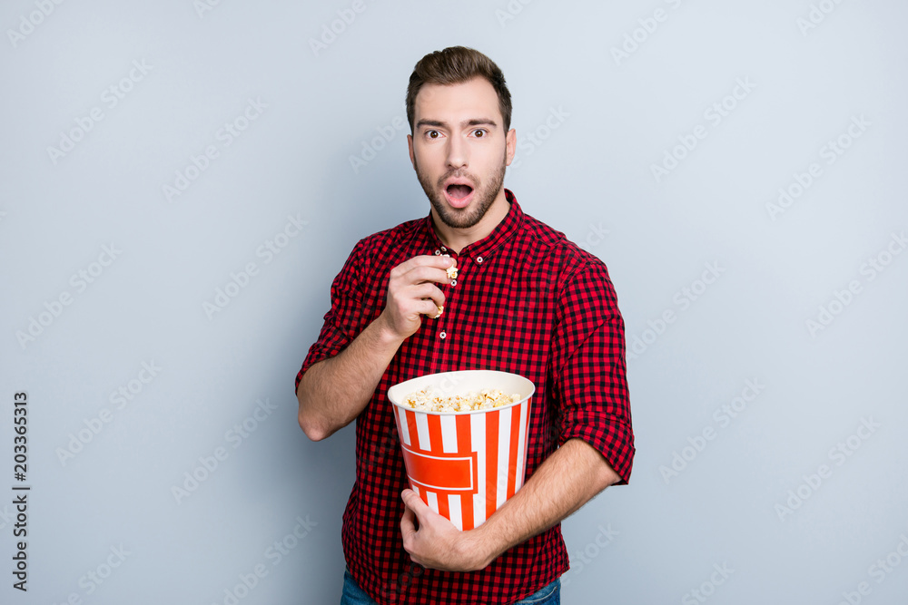 Naklejka premium Wow! Portrait of scared frightened amazed surprised handsome attractive hipster voiceless guy watching the premier of film in the cinema, isolated on gray background