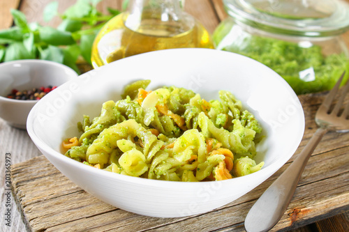 Pasta with pesto sauce on an old wooden table. photo