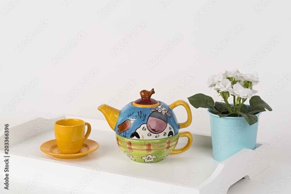 Tetera decorada, taza de té y maceta en bandeja blanca de madera. Stock  Photo | Adobe Stock