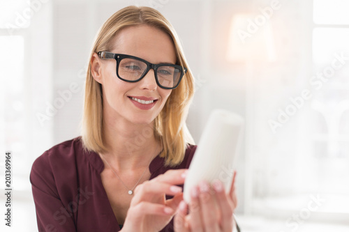 Perfect element. Gay female designer holding sample while wearing glasses
