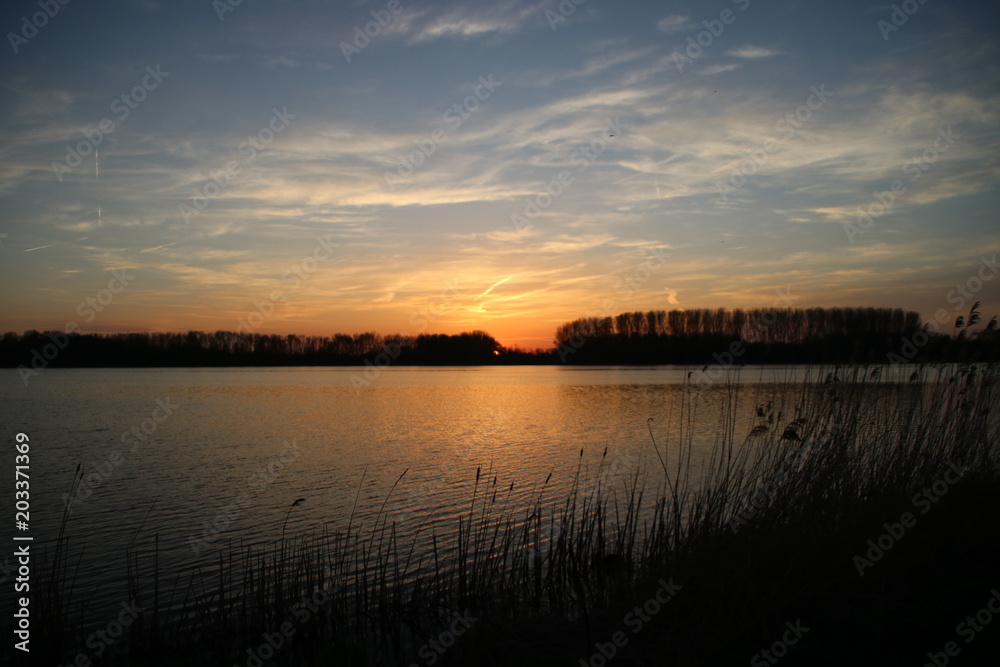 Naklejka premium colorful sunset over river Rotte in Zevenhuizen with reflection in the water in the Netherlands.