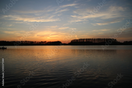 colorful sunset over river Rotte in Zevenhuizen with reflection in the water in the Netherlands. © André Muller