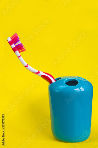 Beautiful multi-colored toothbrush on a yellow background.
