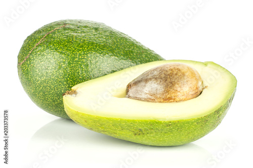 Green smooth avocado and one section half with a seed isolated on white background bacon variety. photo