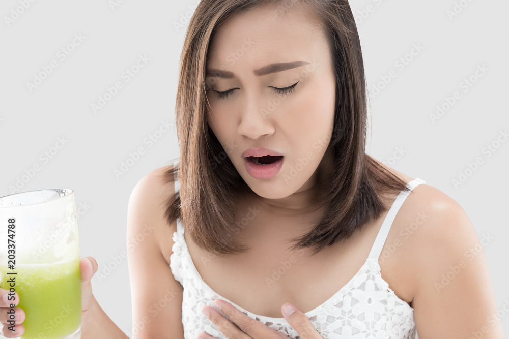 Asian woman is squeamish from the juice against gray background. Asian woman is squeamish from the juice against gray background.