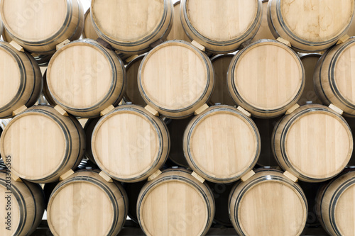 Billede på lærred Wine barrels stacked in the old cellar of the winery