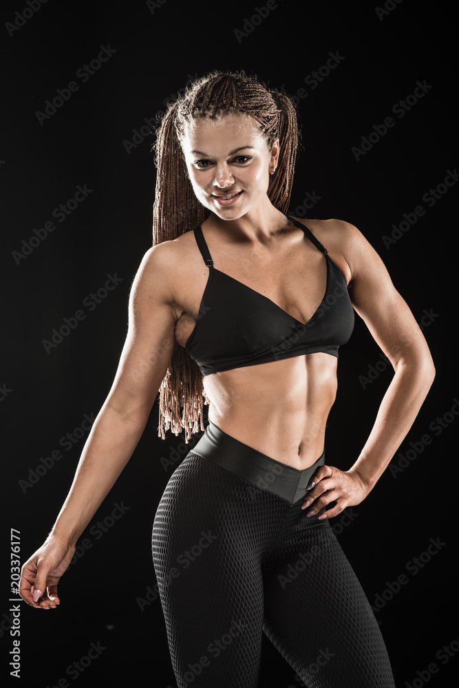 Female fitness model posing on black background Female fitness model posing on black background