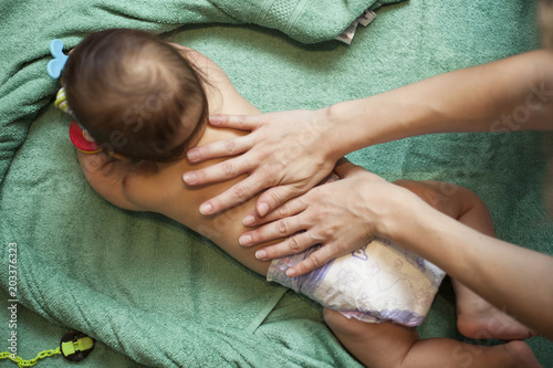 Baby Mother massaging her little baby girl, shallow focus