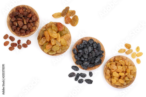 Collection of raisins in wooden bowl isolated on a white background with copy space for your text. Top view. Flat lay photo