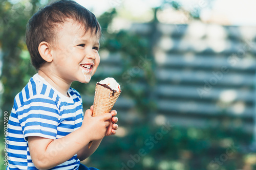 cute little boy in the Park or garden eating ice cream in summer t-shirt