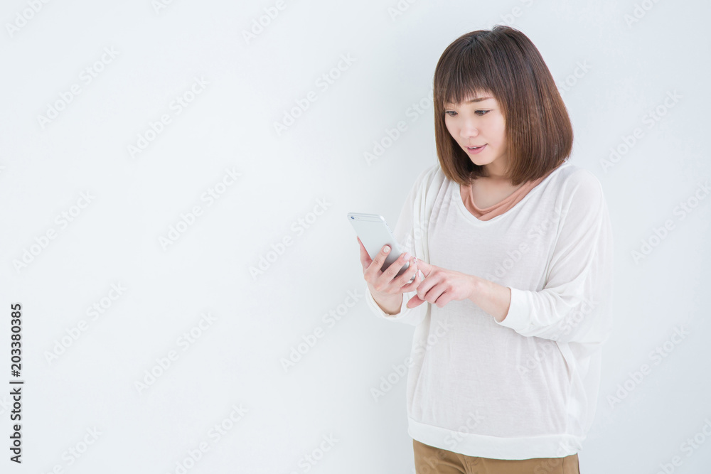 電話を持ってびっくりする女性
電話を持ってびっくりする女性