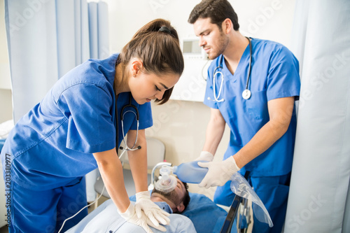 Paramedics performing cpr on a man in emergency room