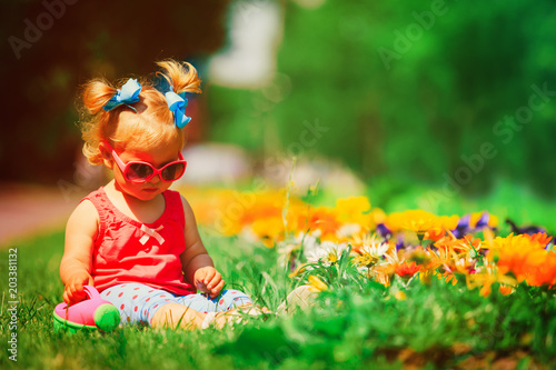 little girl watering flowers in garden