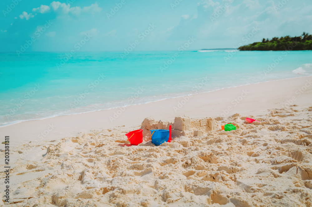 Sand castle and toys on tropical beach Sand castle and toys on tropical beach