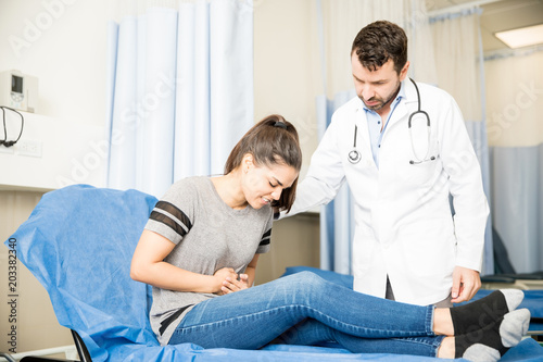 Woman with stomach ache visiting doctor