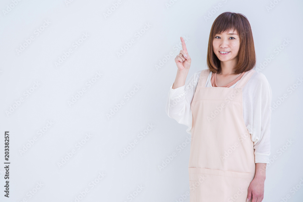 指差すエプロン姿の女性
