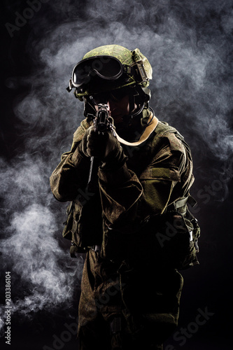 russian special forces soldier with rifle on dark background. army, military and people concept © kaninstudio