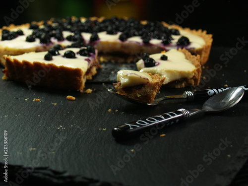 Ciasto z kremem i jagodami, krucha tarta na stole, pokrojona, owoce i wanilia