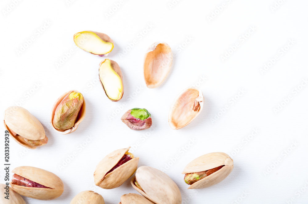 Pistachios nuts on white background, top view. Flat lay Pistachios nuts on white background, top view. Flat lay