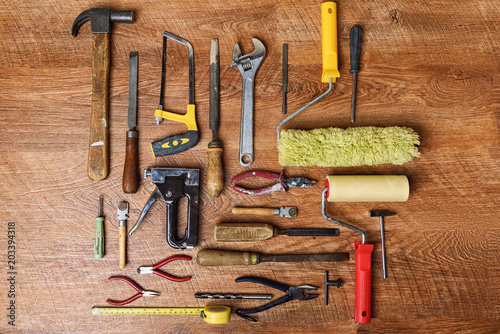 Tools for repair: a hammer, drills, pliers, platens, screwdrivers, glass cutters, staplers on a wooden background photo