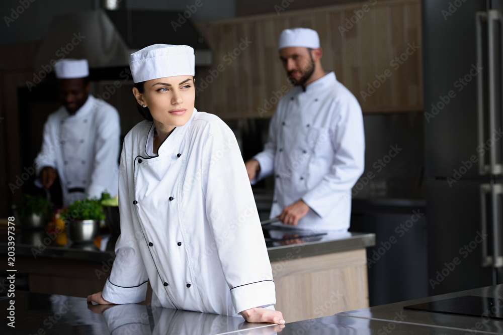 beautiful chef looking away at restaurant kitchen